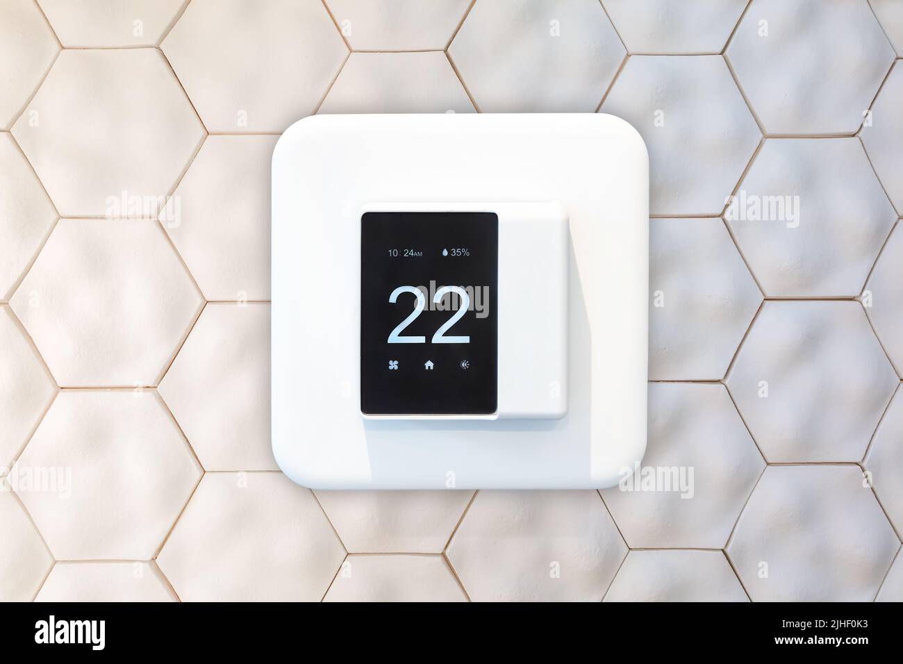 Intelligenter Thermostat, der an einer Umweltwand aus recyceltem Material hängt Stockfoto