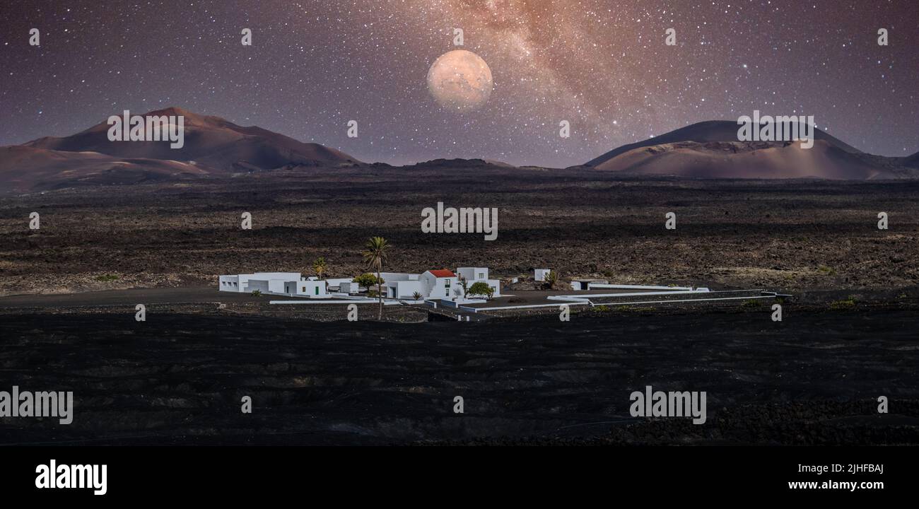 Atemberaubende nächtliche Panoramalandschaft mit Vulkankrater im Timanfaya Nationalpark. Vollmond über La Gueria, Lanzarote, Kanarische Inseln, Spanien Stockfoto