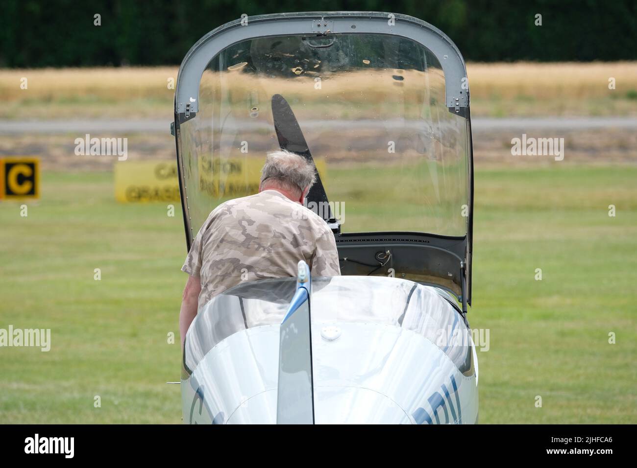 Ein Pilot steigt in seine zwei Sitze Seite an Seite Vans RV-6 Leichtflugzeug auf einem Flugplatz in Großbritannien Stockfoto