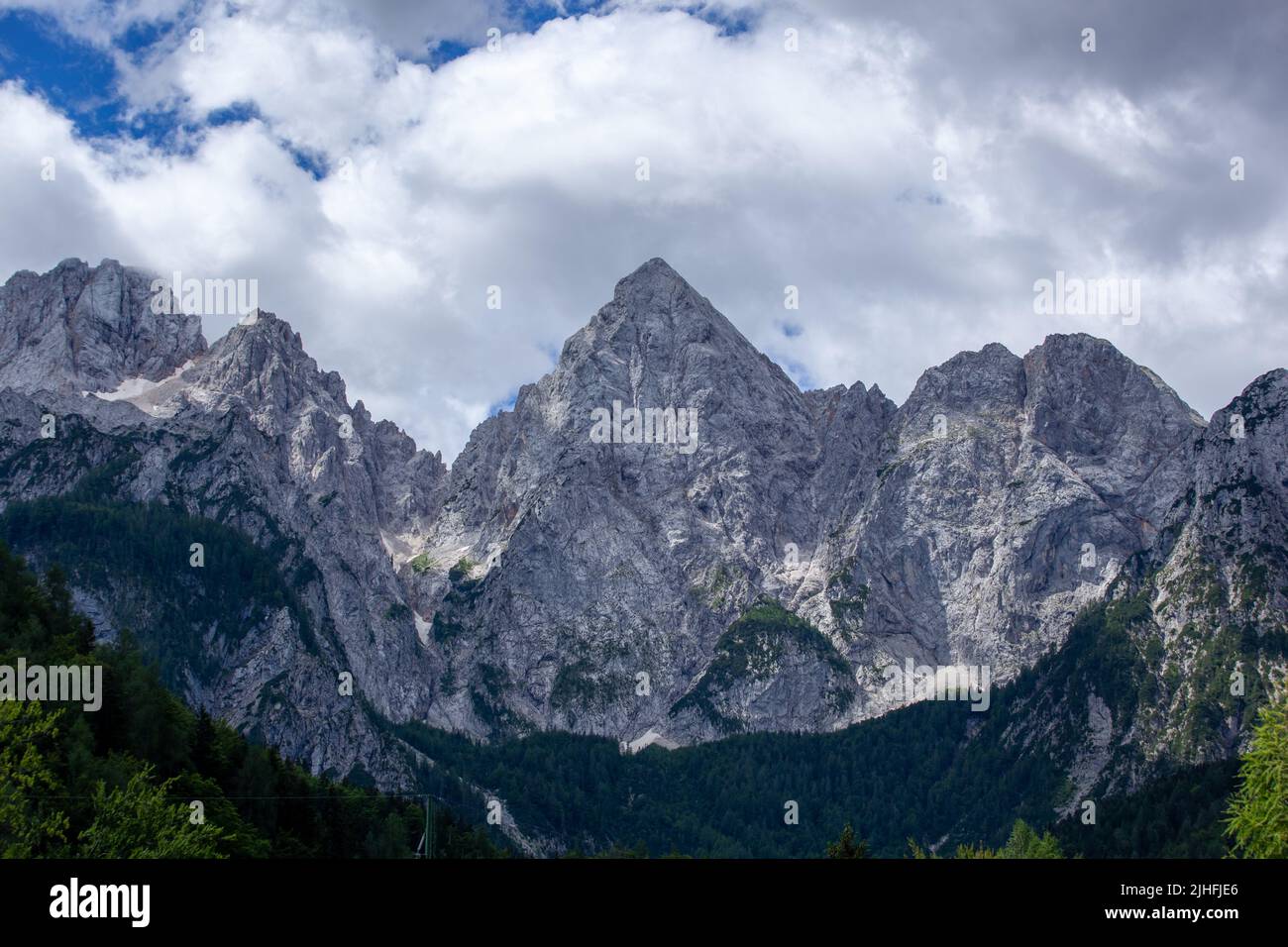 Die Gipfel liegen in der Sonne. Der Himmel ist bedeckt, aber zeigt blauen Himmel. Spik Peak ist deutlich sichtbar. Stockfoto