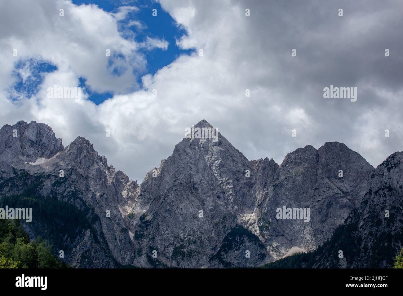 Die Gipfel liegen in der Sonne. Der Himmel ist bedeckt, aber zeigt blauen Himmel. Spik Peak ist deutlich sichtbar. Stockfoto