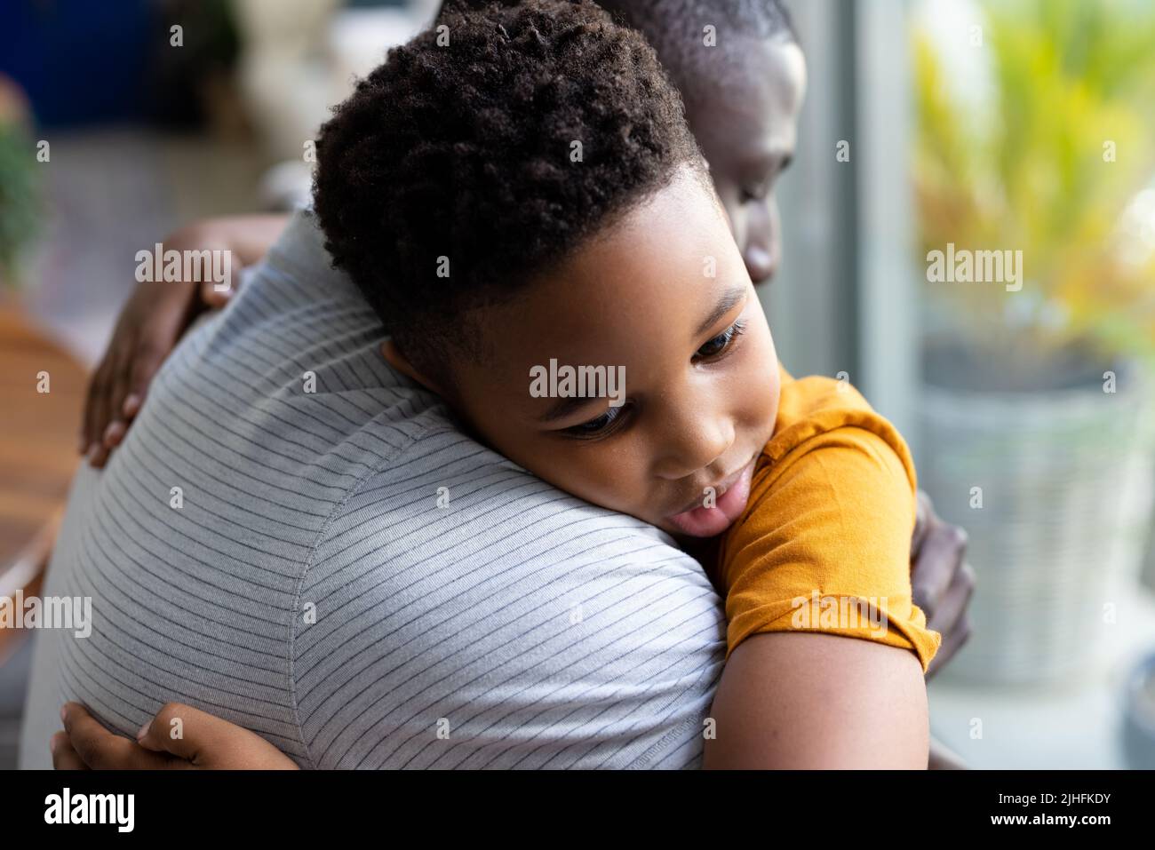 Bild von afroamerikanischem Vater und Sohn, der sich umarmt Stockfoto