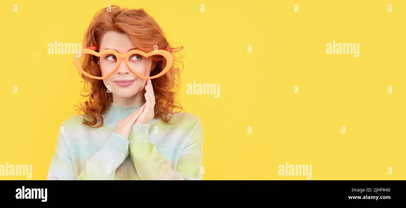 Frau isoliert Gesicht Porträt, Banner mit Kopieplatz. Glücklich Rotschopf Frau tragen lustige Party-Brille auf gelbem Hintergrund, Partei. Stockfoto
