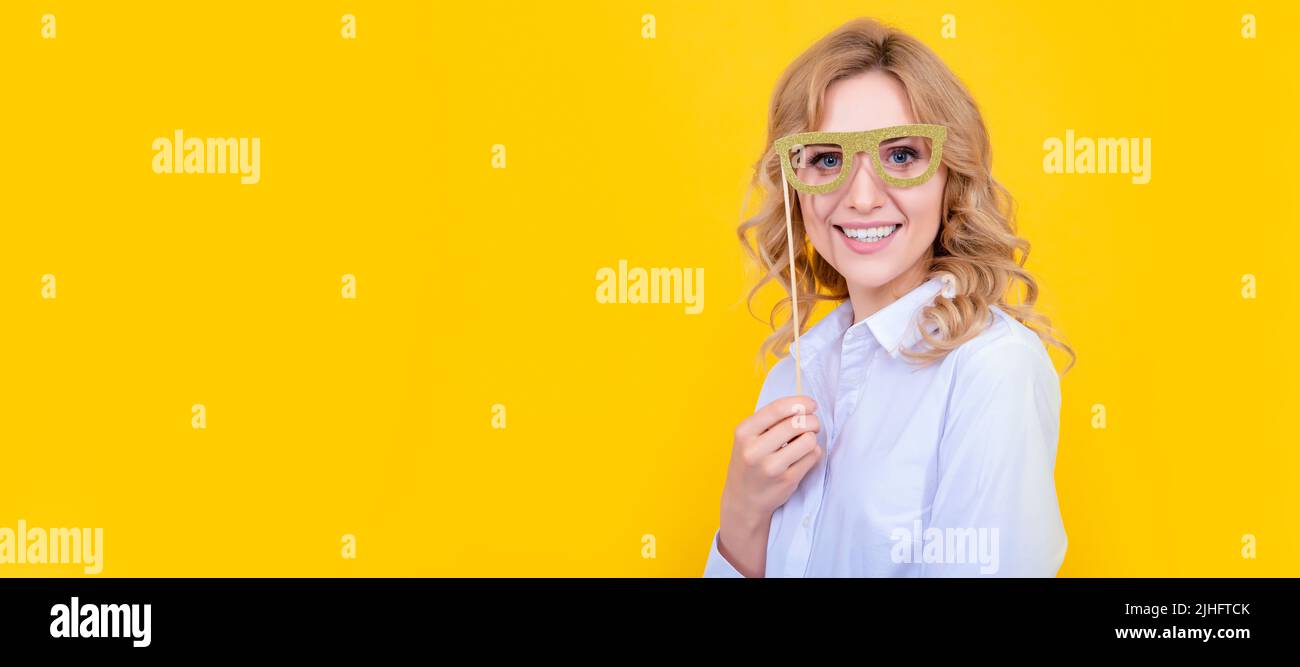 Positive Frau mit lustigen Partybrillen auf gelbem Hintergrund. Frau isoliert Gesicht Porträt, Banner mit Mock-up-Kopie Platz. Stockfoto