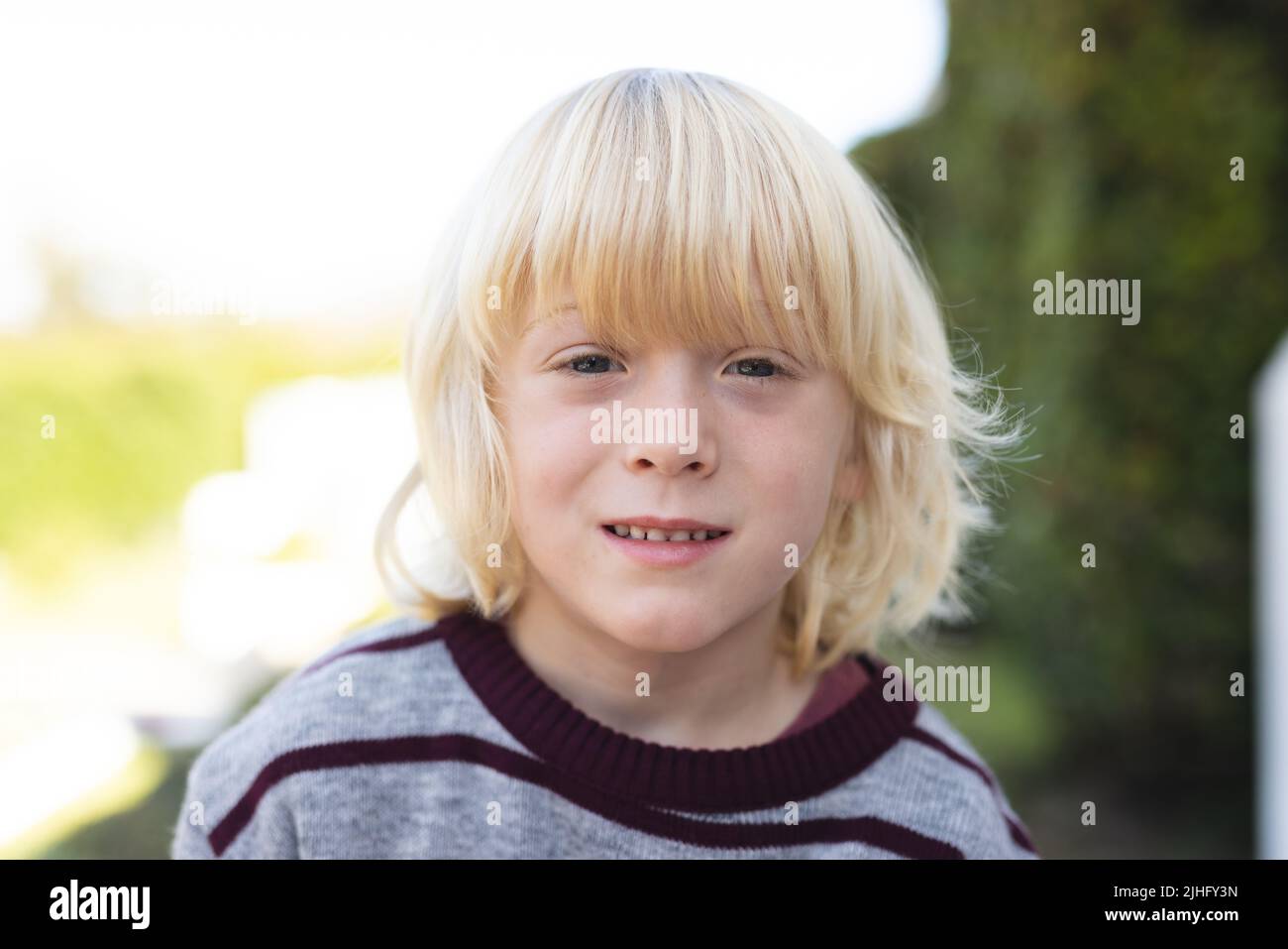 Bild eines glücklichen kaukasischen Jungen, der vor der Kamera lächelt Stockfoto