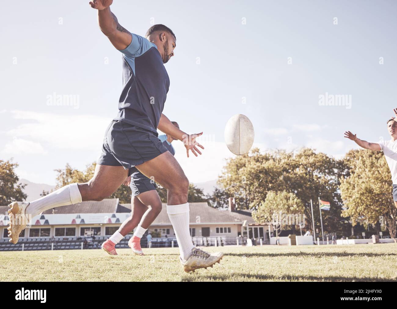 Mixed Race Rugby-Spieler, der während eines Rugby-Spiels draußen auf dem Spielfeld einen dropkick versucht. Hispanischer Mann tritt wegen Berührung oder versucht, drei Punkte zu erzielen Stockfoto
