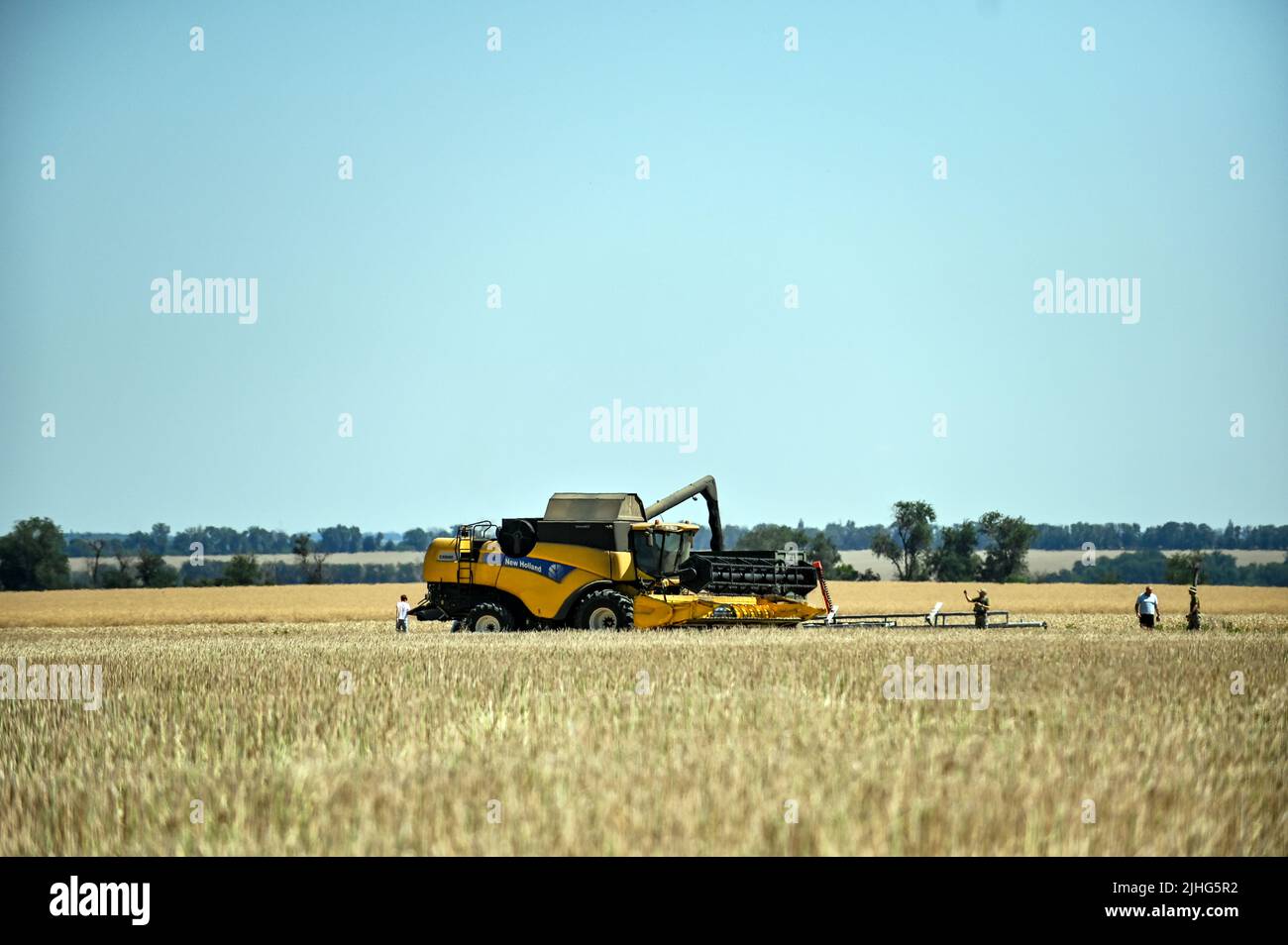 REGION SAPORISCHSCHSCHJA, UKRAINE - 17. JULI 2022 - Ein Mähdrescher verstauen Weizen auf dem Feld, Region Saporischschschja, Südosten der Ukraine. Dieses Foto kann Stockfoto