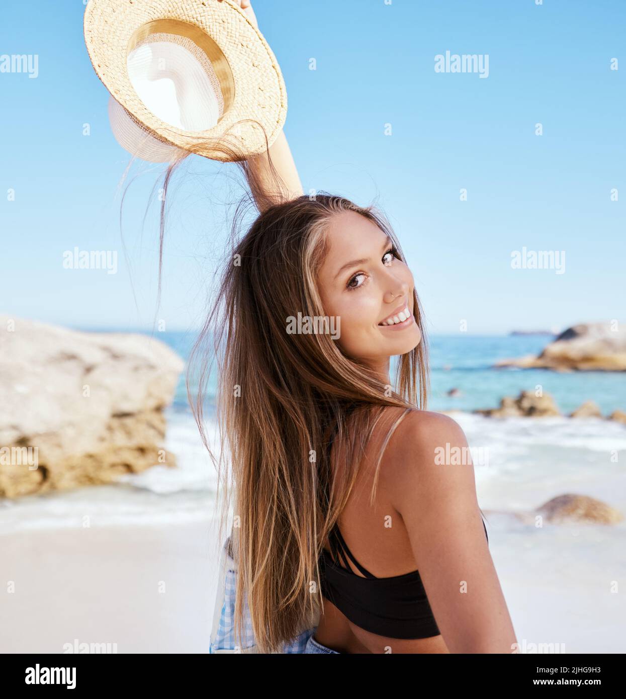 Eine wunderschöne junge kaukasische Frau, die sich am Strand entspannt. Genießen Sie einen Sommerurlaub oder Urlaub im Freien im Sommer. Sich Zeit nehmen und immer Stockfoto