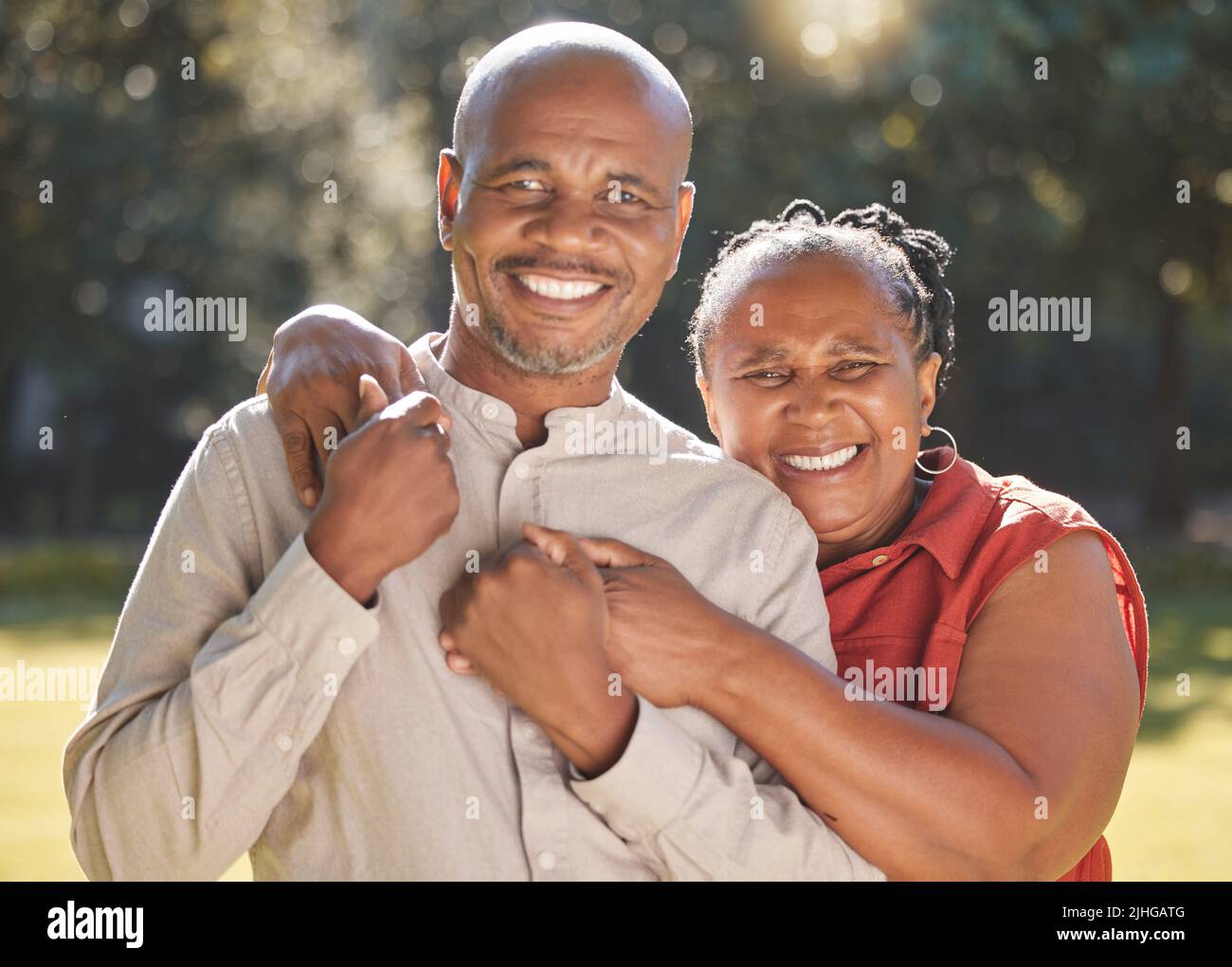 Portrait glücklich liebevolles reifes afroamerikanisches Paar, das während des Sommers einen intimen Moment draußen im Park teilt. Verliebte ältere Erwachsene lächeln Stockfoto