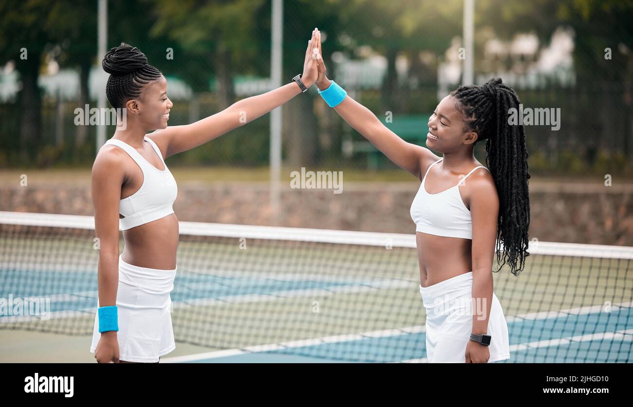 Glückliche Profi-Tennisspieler mit fünf nach einem Spiel auf dem Platz. Junge Mädchen unterstützen sich nach dem Tennistrachen gegenseitig. Zwei Freunde, die sich miteinander verbinden Stockfoto