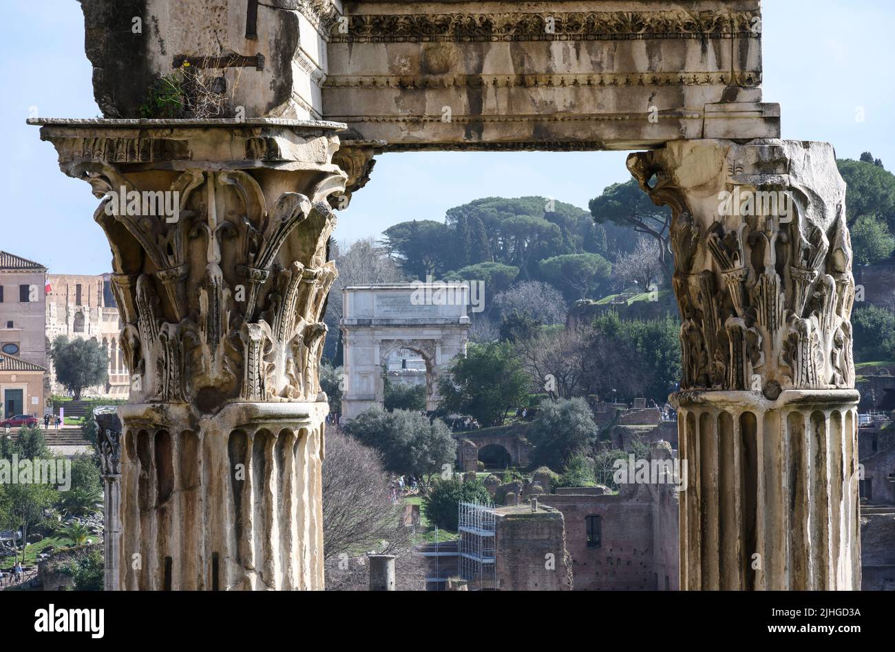 Blick auf den Titusbogen durch die korinthischen Säulen des Vespasianertempels und Titus im Forum Romanum, Zentralroman, Latium, Italien. Stockfoto