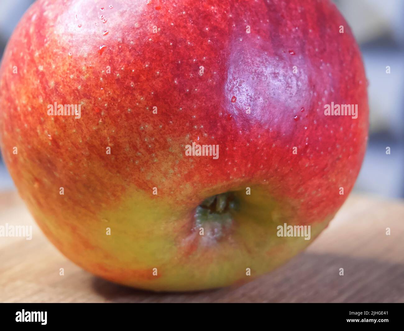 Ein großer roter Apfel auf einer hölzernen Oberfläche Stockfoto