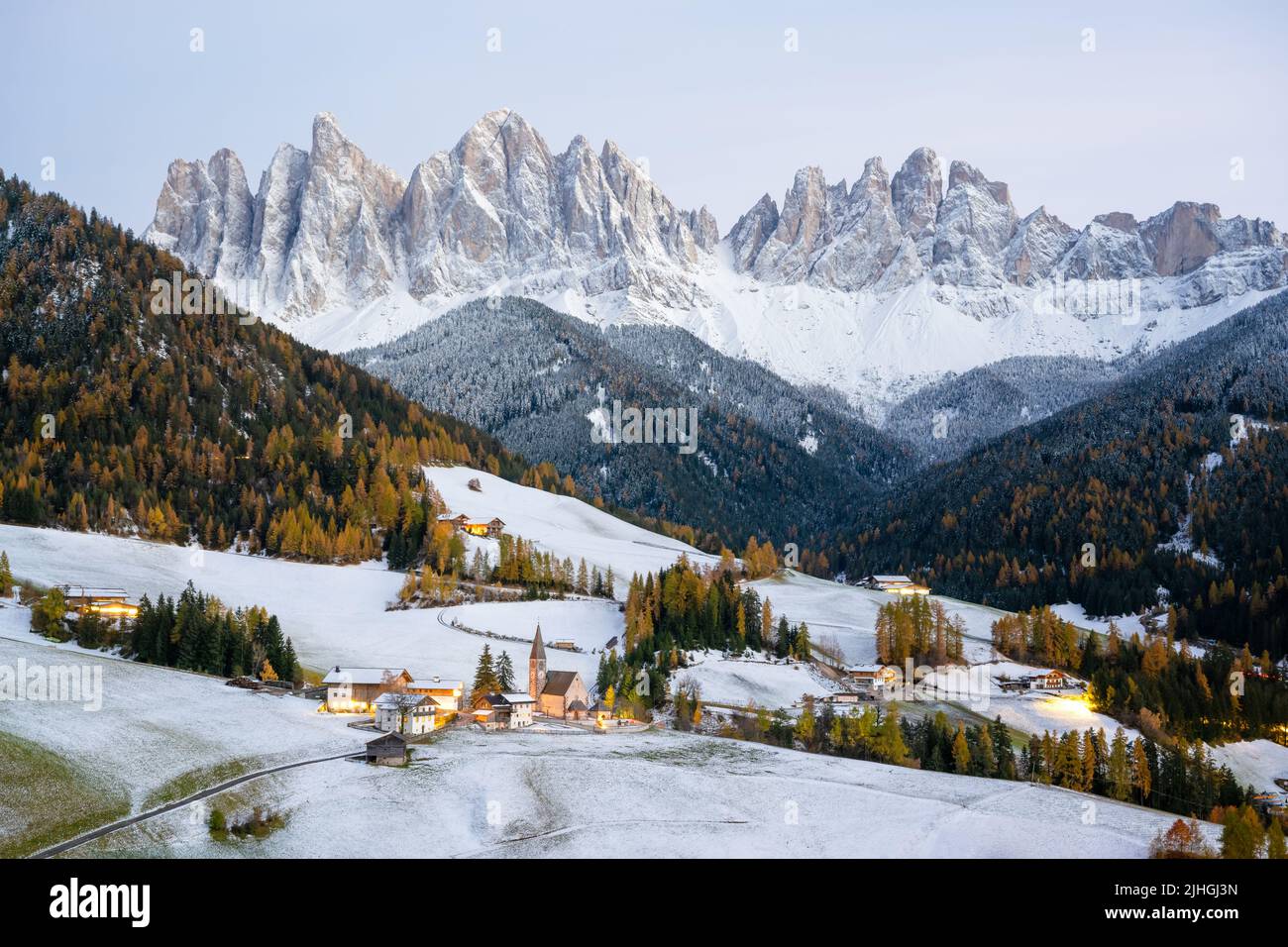 Das berühmte Bergdorf Santa Magdalena mit der Kirche Santa Maddalena in den herbstlichen Dolomiten. Verschneite Berggruppe der Geisler im Hintergrund. Val di Funes, Südtirol, Italien Stockfoto