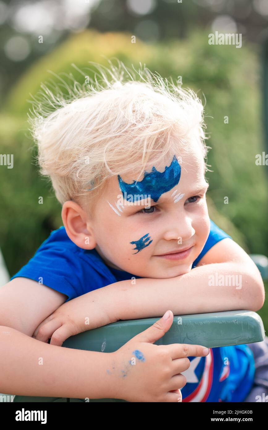 Niedlicher kleiner Junge mit Gesichtsfarbe mit batman-Muster. Gesichtsbemalung, Kindergesicht auf der Geburtstagsfeier Stockfoto