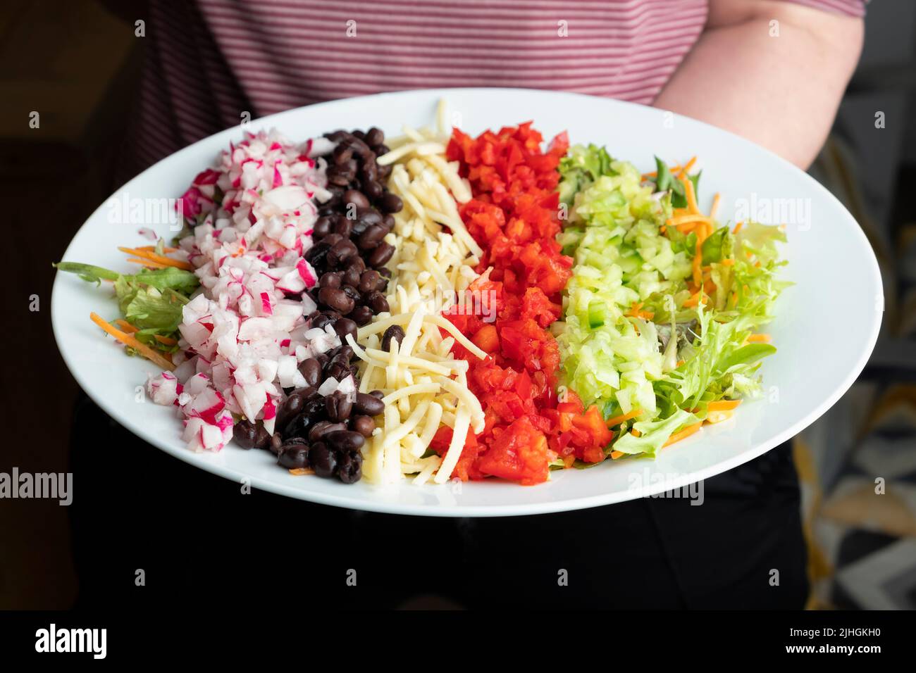 Ein amerikanischer gehackter Salat. Die sorgfältig angeordneten Salatzutaten sind Teil einer gesunden mediterranen Ernährung und tragen zu Ihren 5 pro Tag bei Stockfoto