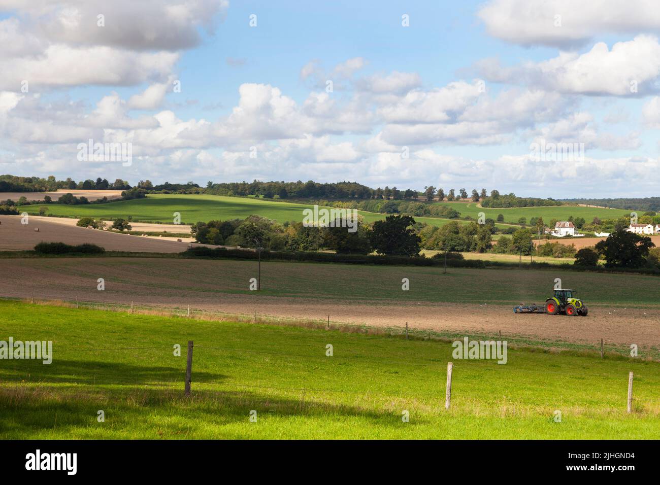 Ein Traktor bewirtschaftet das Land auf einem Bauernhof Stockfoto