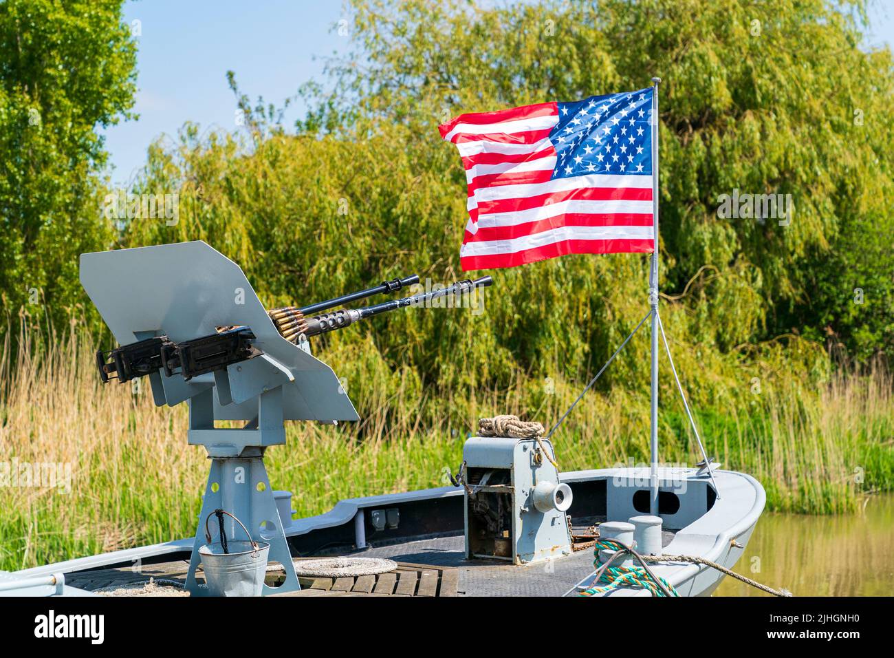 Amerikanische Flagge flattert im Wind neben einem Zwillings-Revolver mit M1919 Browning-Maschinengewehr auf dem Bogendeck des US-Marine-Patrouillenbootes, P22 in Sandwich, Ken Stockfoto