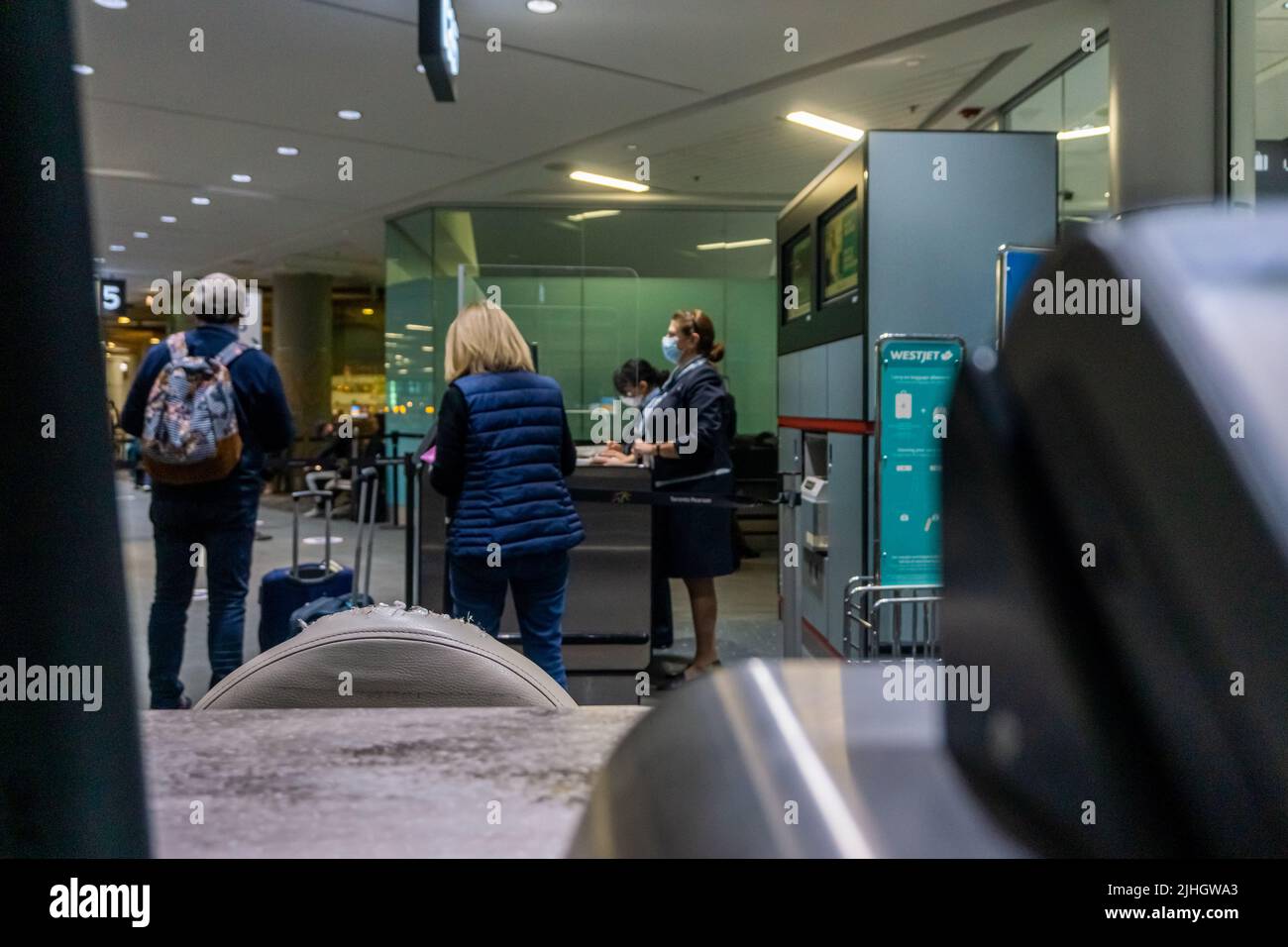 Internationaler Flughafen Toronto, Kanada, November 2021 - Bodenabfertigungsmitarbeiter, die Passagiere am Schalter am Boarding Gate bedienen Stockfoto