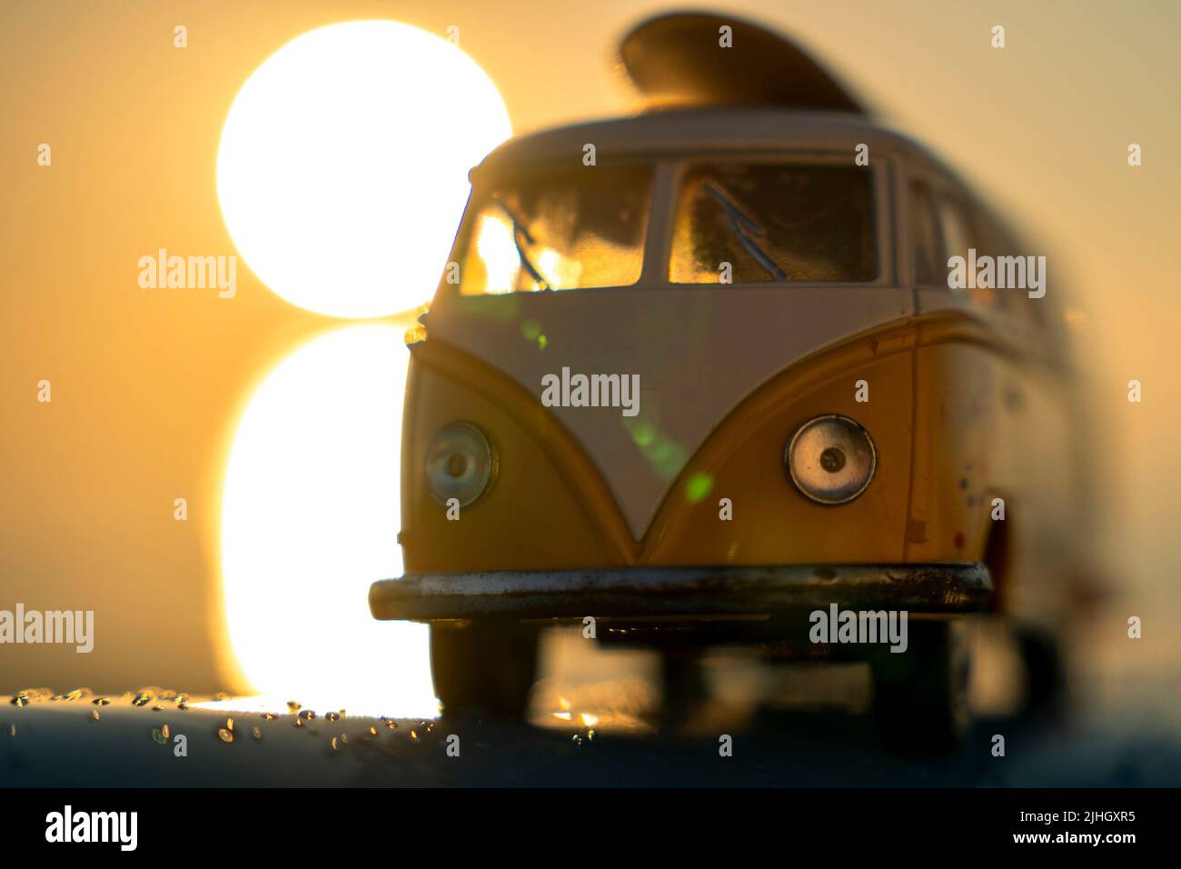 Minibus mit Surfen auf dem Dach in den Strahlen der untergehenden Sonne Stockfoto