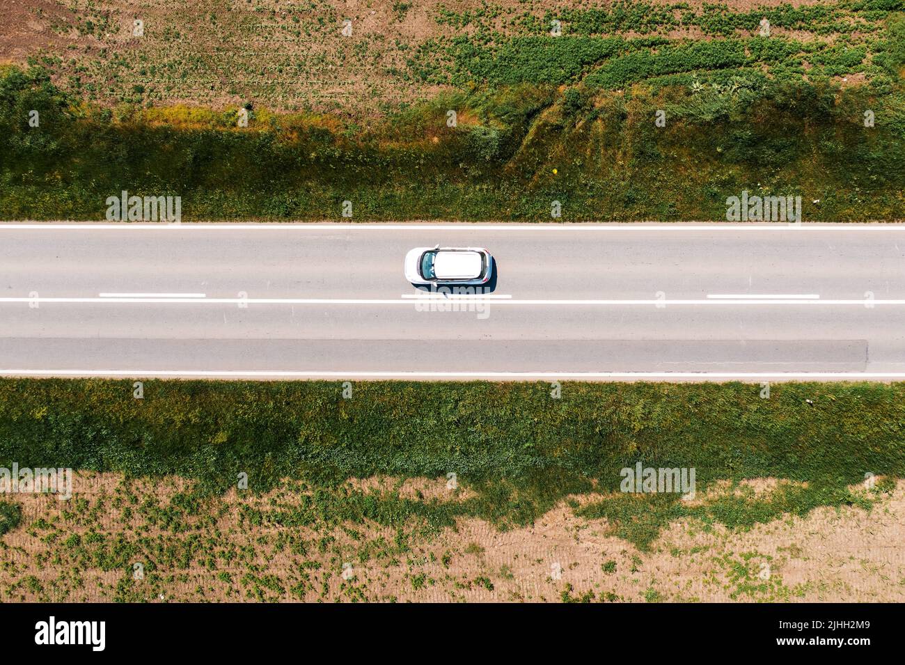 Fahrt mit dem Auto auf offener Autobahn durch grüne Frühlingslandschaft, Luftaufnahme von Drohne pov von oben nach unten Stockfoto