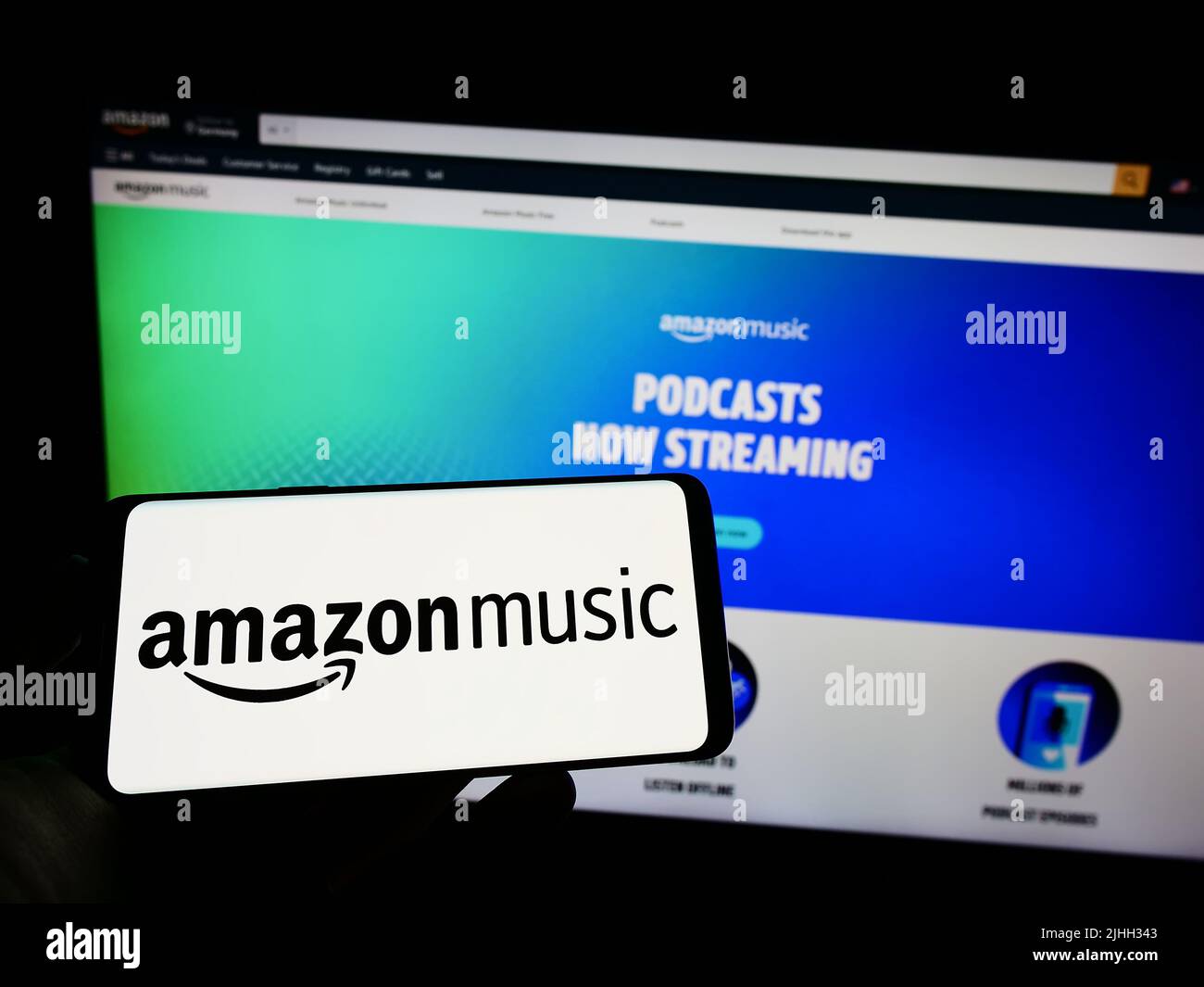Person, die ein Mobiltelefon mit dem Logo des amerikanischen Streaming-Dienstes Amazon Music auf dem Bildschirm vor der Unternehmenswebseite hält. Konzentrieren Sie sich auf die Telefonanzeige. Stockfoto