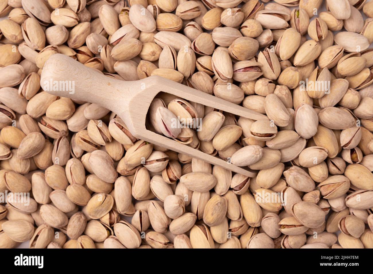 Pistazie in Holzlöffel auf dem Hintergrund vieler Nüsse Nahaufnahme, natürlicher Hintergrund für gesunde Ernährung Konzept, Bio roh gesunde Ernährung, Draufsicht Stockfoto