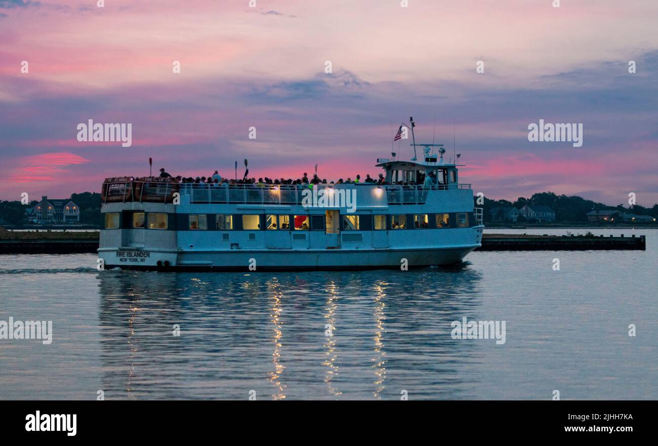 Bay Shore, New York, USA - 14. Juli 2022: Eine Fire Island Fähre bringt Passagiere nach Fire Island bei Sonnenaufgang. Stockfoto