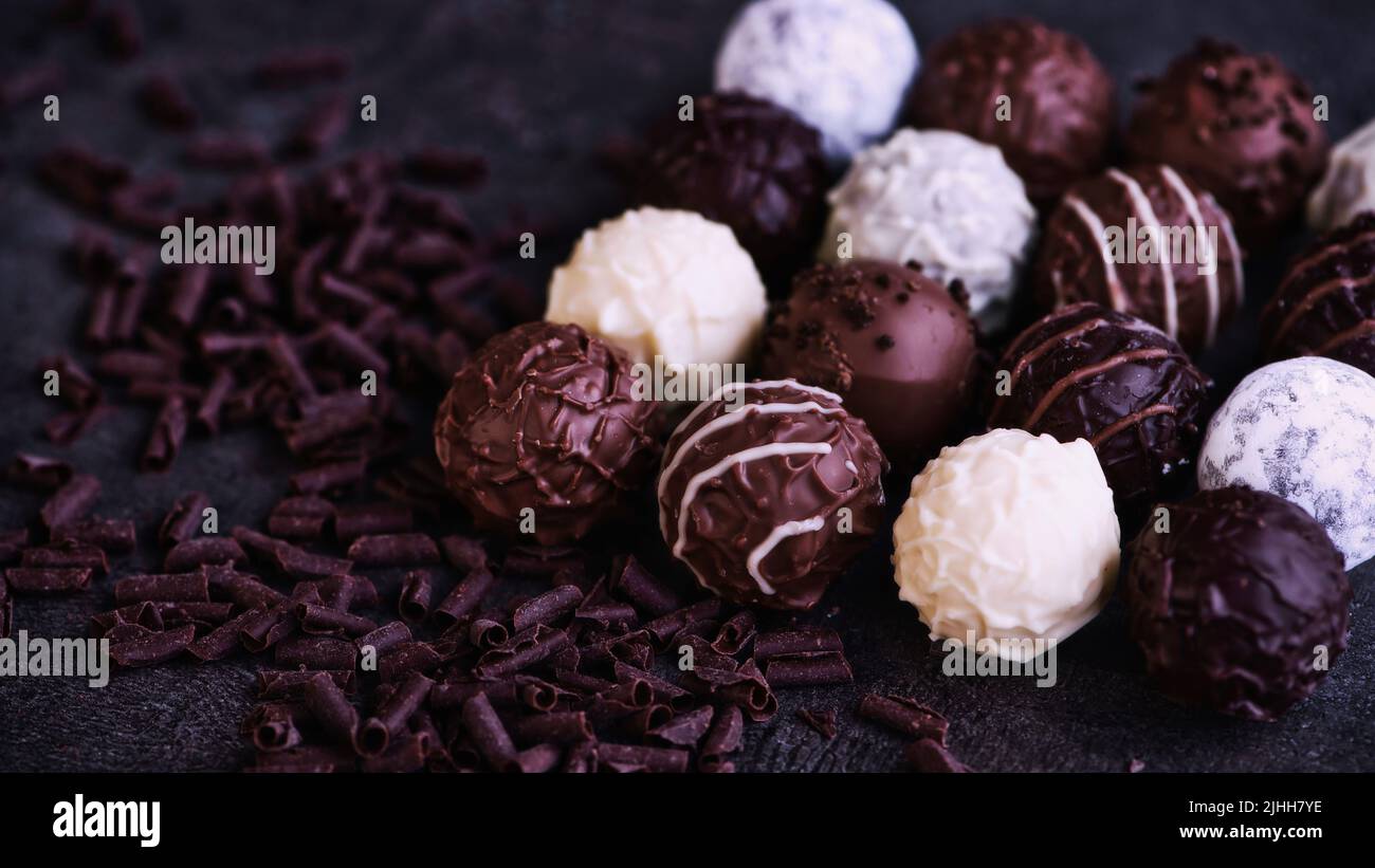 Sechzehn Schokoladentrüffel neben einigen Schokoladenflocken Stockfoto
