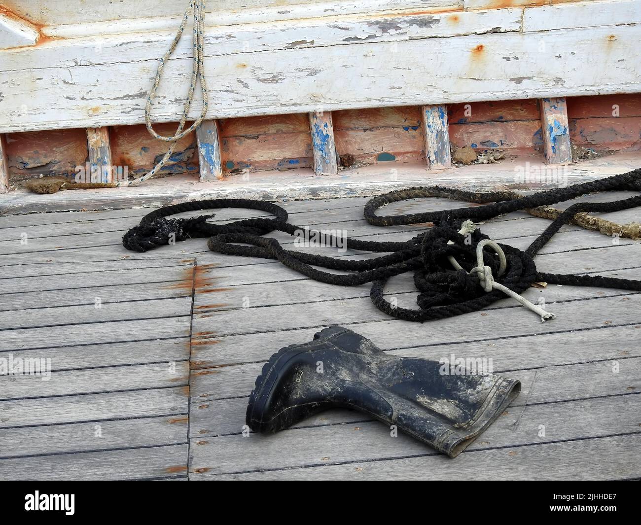Seile und Gummistiefel auf dem Deck des Fischerbootes Stockfoto