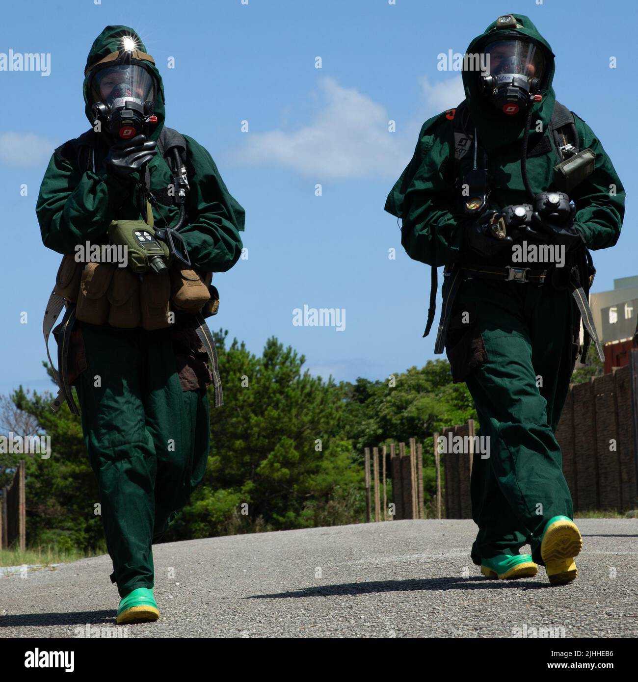 U.S. Marine Corps CPL. Aselia Isakova und CPL. Gabriela Gonzalez, beide Spezialisten für chemische, biologische, radiologische und nukleare Verteidigung beim Bataillon für Kampflogistik 31, 31. Marine Expeditionary Unit; Wanderung in Richtung einer kontaminierten Zone während einer CBRN Response Element Übung auf Okinawa, Japan, 11. Juli 2022. Eine CRE-EX testet die Fähigkeit der CBRN, auf verschiedene Operationen zu reagieren, einschließlich der Untersuchung von geheimen Laboren, die chemische Munitionsmittel enthalten, und der Bekämpfung von Massenvernichtungswaffen, während sie Aufklärungen, Dekontaminationen und schnelle Einfügungen bei Verletzten durchführt. Die 31. MEU, die Stockfoto