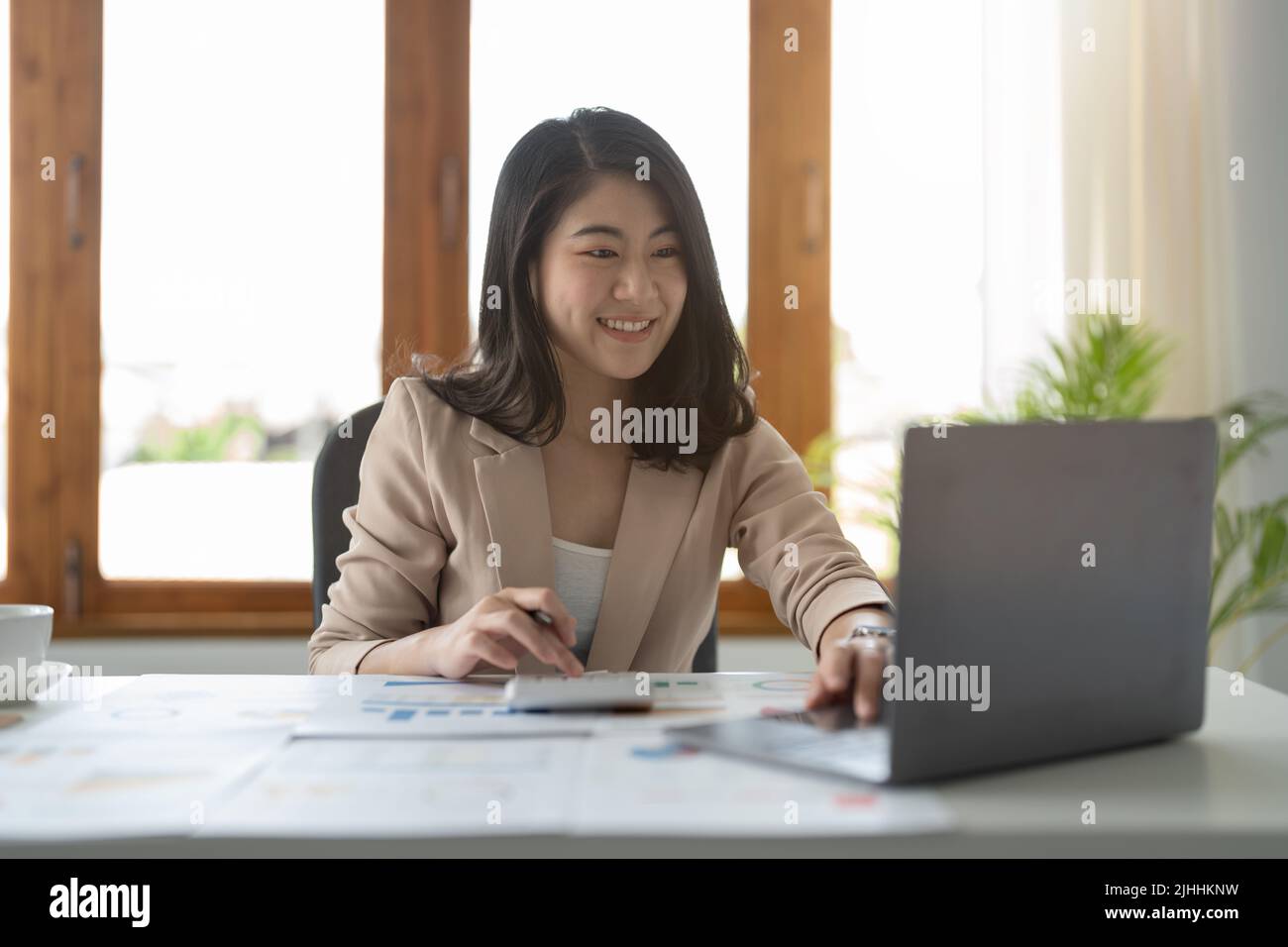 Portrait von attraktiven asiatischen erfahrenen professionellen Mädchen Agent Broker Executive Assistant Berechnung Einkommen Gewinn bei modernen Loft Industrial Stockfoto
