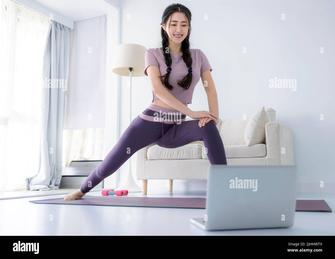 Junge asiatische gesunde Frau Training zu Hause, Heimfitness-Konzept Stockfoto