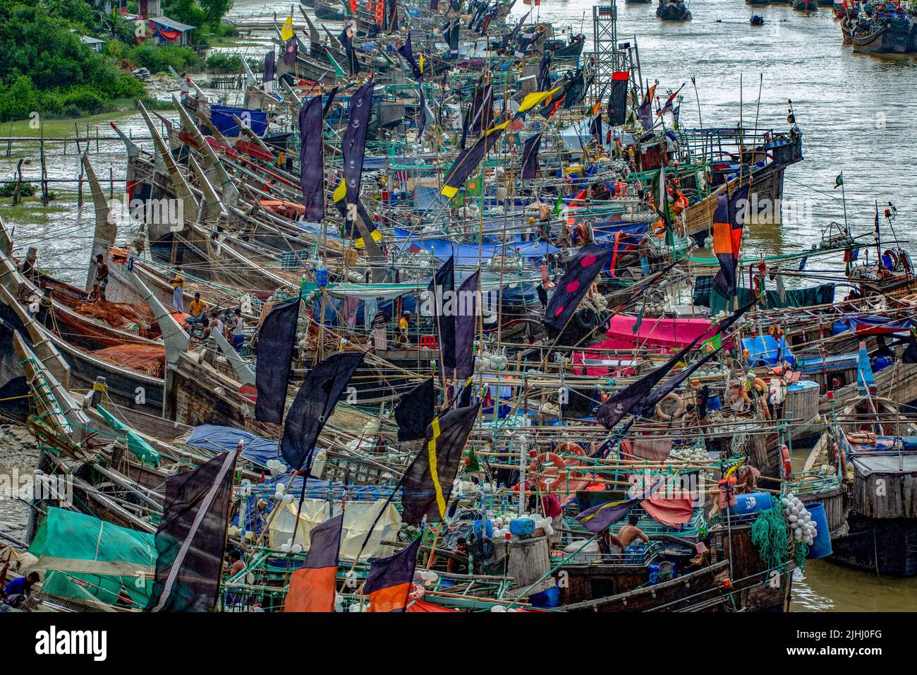 Am Flussufer sind hölzerne Boote aufgestellt, die verschiedene schöne visuelle Muster geschaffen haben. Stockfoto