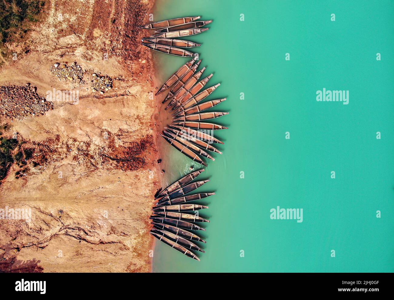 Am Flussufer sind hölzerne Boote aufgestellt, die verschiedene schöne visuelle Muster geschaffen haben. Stockfoto