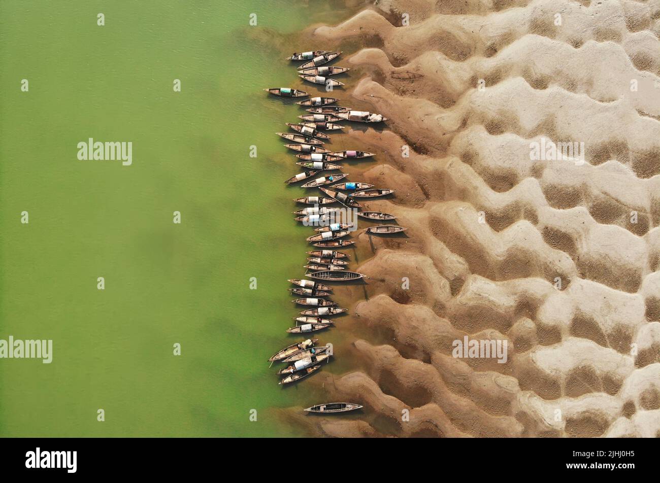 Am Flussufer sind hölzerne Boote aufgestellt, die verschiedene schöne visuelle Muster geschaffen haben. Stockfoto