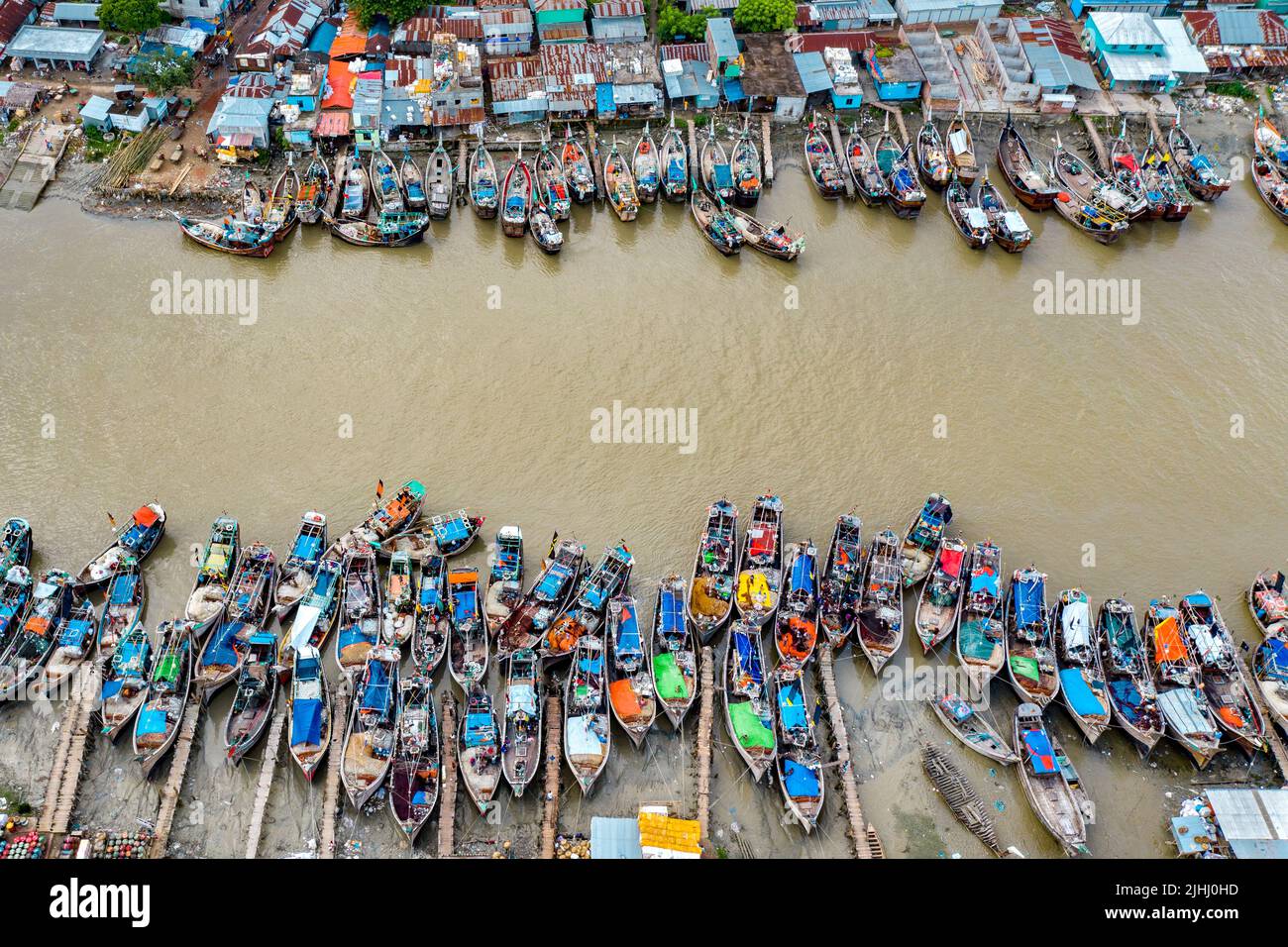 Am Flussufer sind hölzerne Boote aufgestellt, die verschiedene schöne visuelle Muster geschaffen haben. Stockfoto