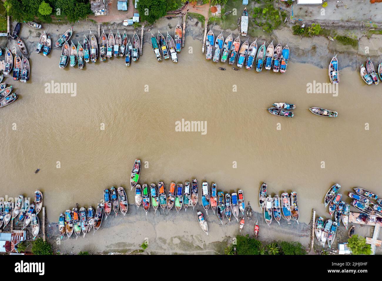 Am Flussufer sind hölzerne Boote aufgestellt, die verschiedene schöne visuelle Muster geschaffen haben. Stockfoto