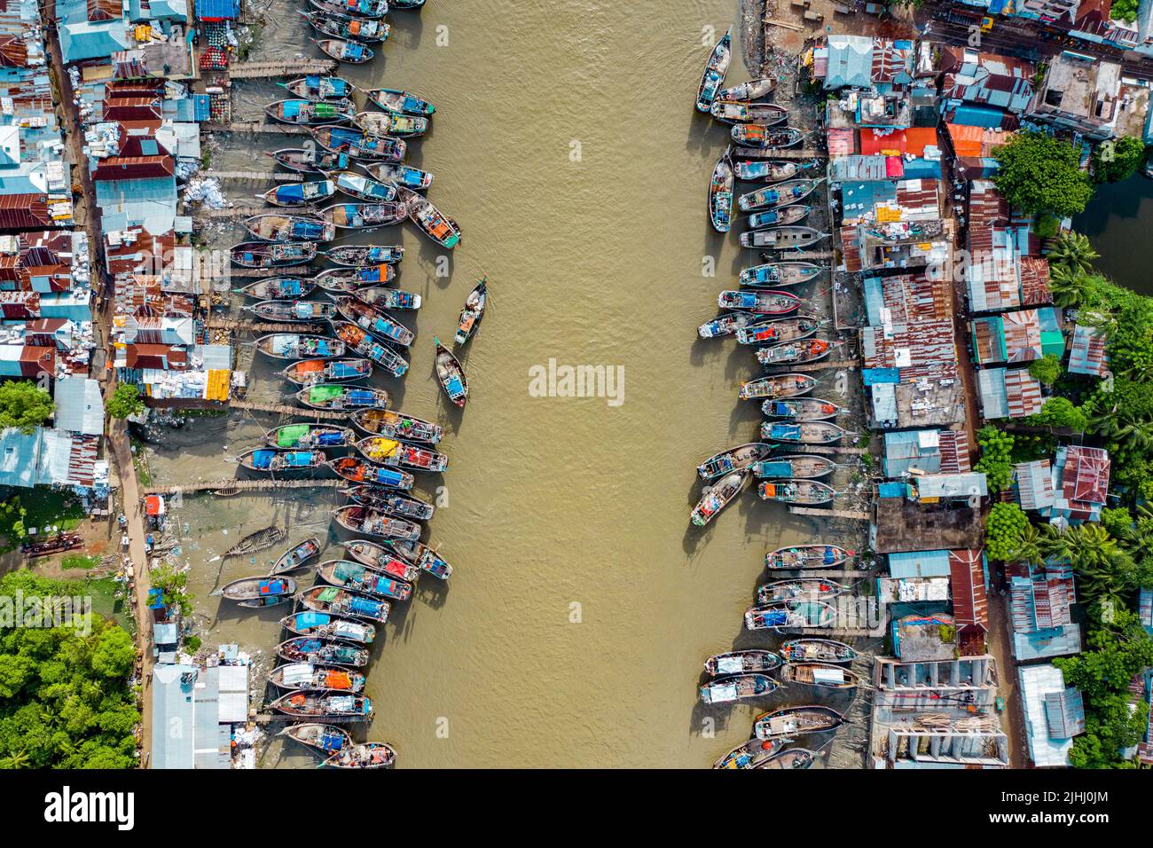 Am Flussufer sind hölzerne Boote aufgestellt, die verschiedene schöne visuelle Muster geschaffen haben. Stockfoto