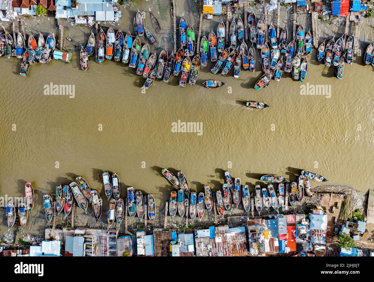 Am Flussufer sind hölzerne Boote aufgestellt, die verschiedene schöne visuelle Muster geschaffen haben. Stockfoto