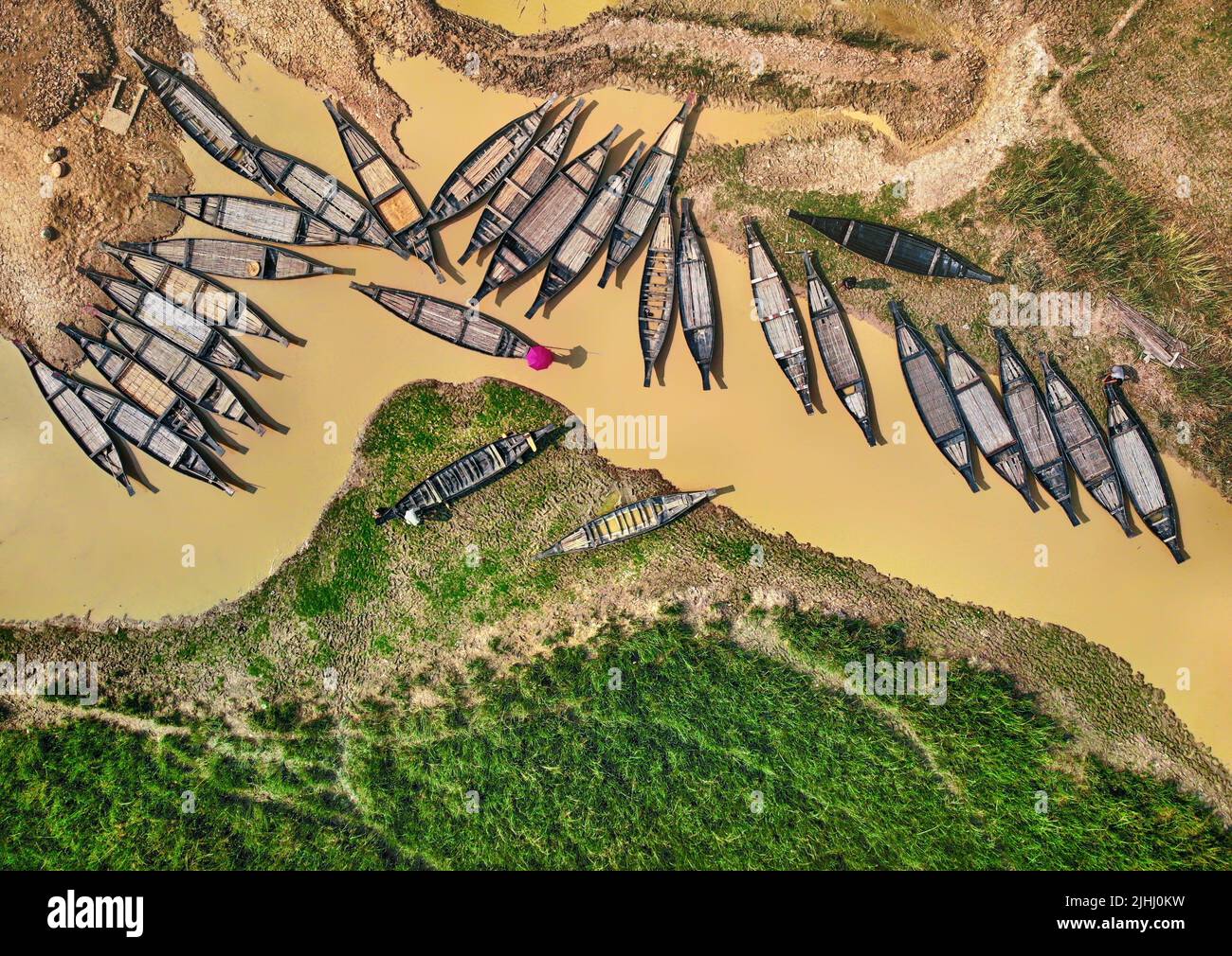 Am Flussufer sind hölzerne Boote aufgestellt, die verschiedene schöne visuelle Muster geschaffen haben. Stockfoto