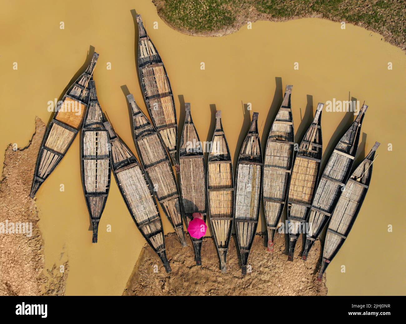 Am Flussufer sind hölzerne Boote aufgestellt, die verschiedene schöne visuelle Muster geschaffen haben. Stockfoto