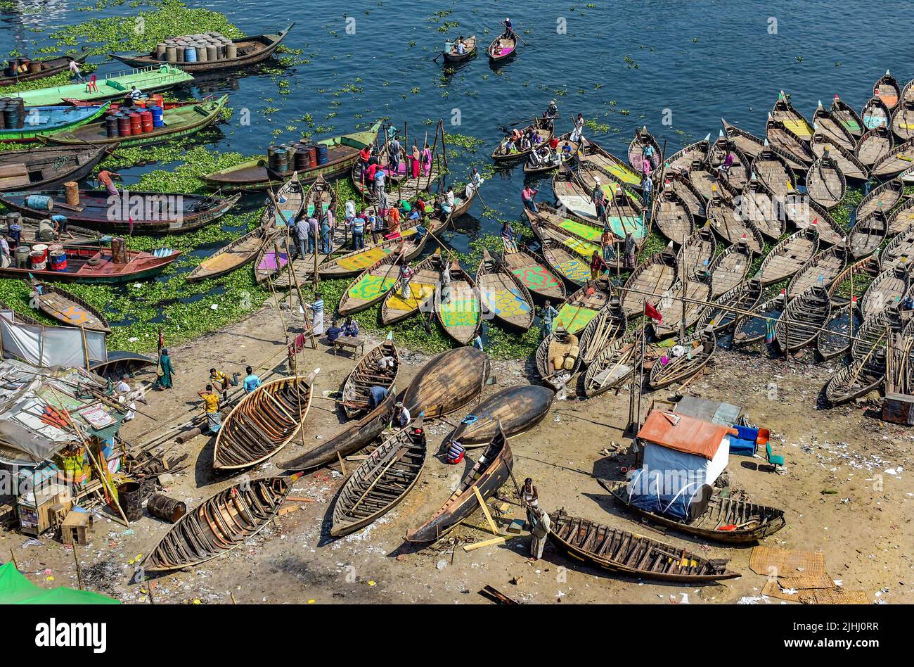 Am Flussufer sind hölzerne Boote aufgestellt, die verschiedene schöne visuelle Muster geschaffen haben. Stockfoto