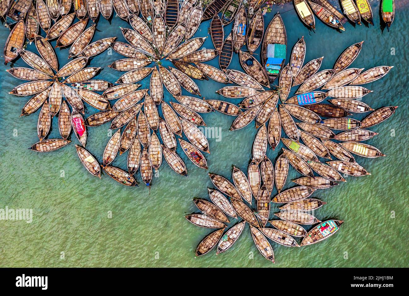 Am Flussufer sind hölzerne Boote aufgestellt, die verschiedene schöne visuelle Muster geschaffen haben. Stockfoto