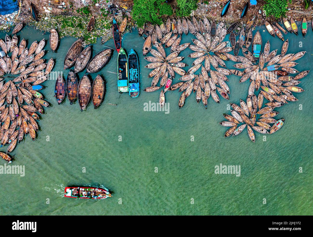 Am Flussufer sind hölzerne Boote aufgestellt, die verschiedene schöne visuelle Muster geschaffen haben. Stockfoto