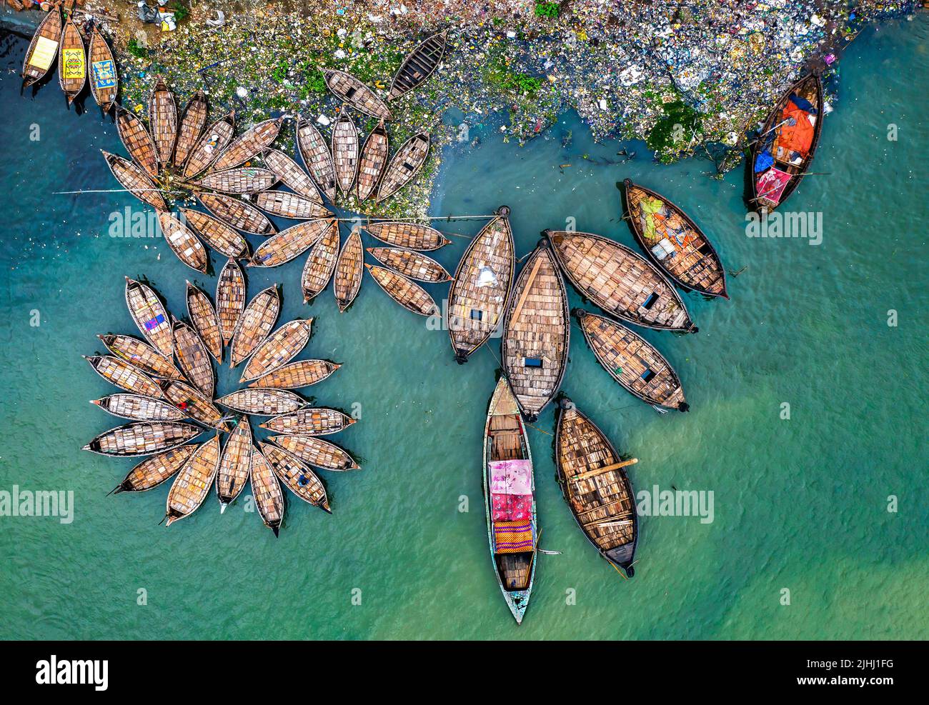 Am Flussufer sind hölzerne Boote aufgestellt, die verschiedene schöne visuelle Muster geschaffen haben. Stockfoto