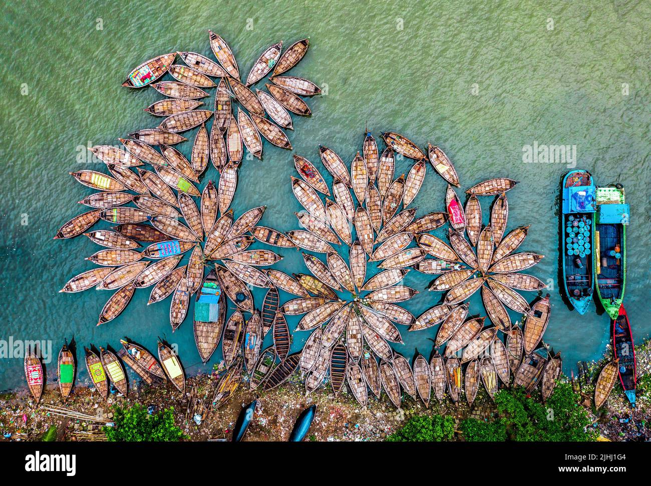 Am Flussufer sind hölzerne Boote aufgestellt, die verschiedene schöne visuelle Muster geschaffen haben. Stockfoto