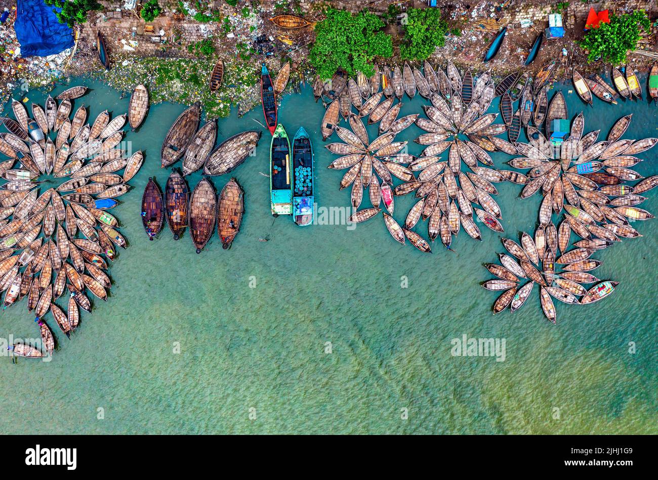 Am Flussufer sind hölzerne Boote aufgestellt, die verschiedene schöne visuelle Muster geschaffen haben. Stockfoto