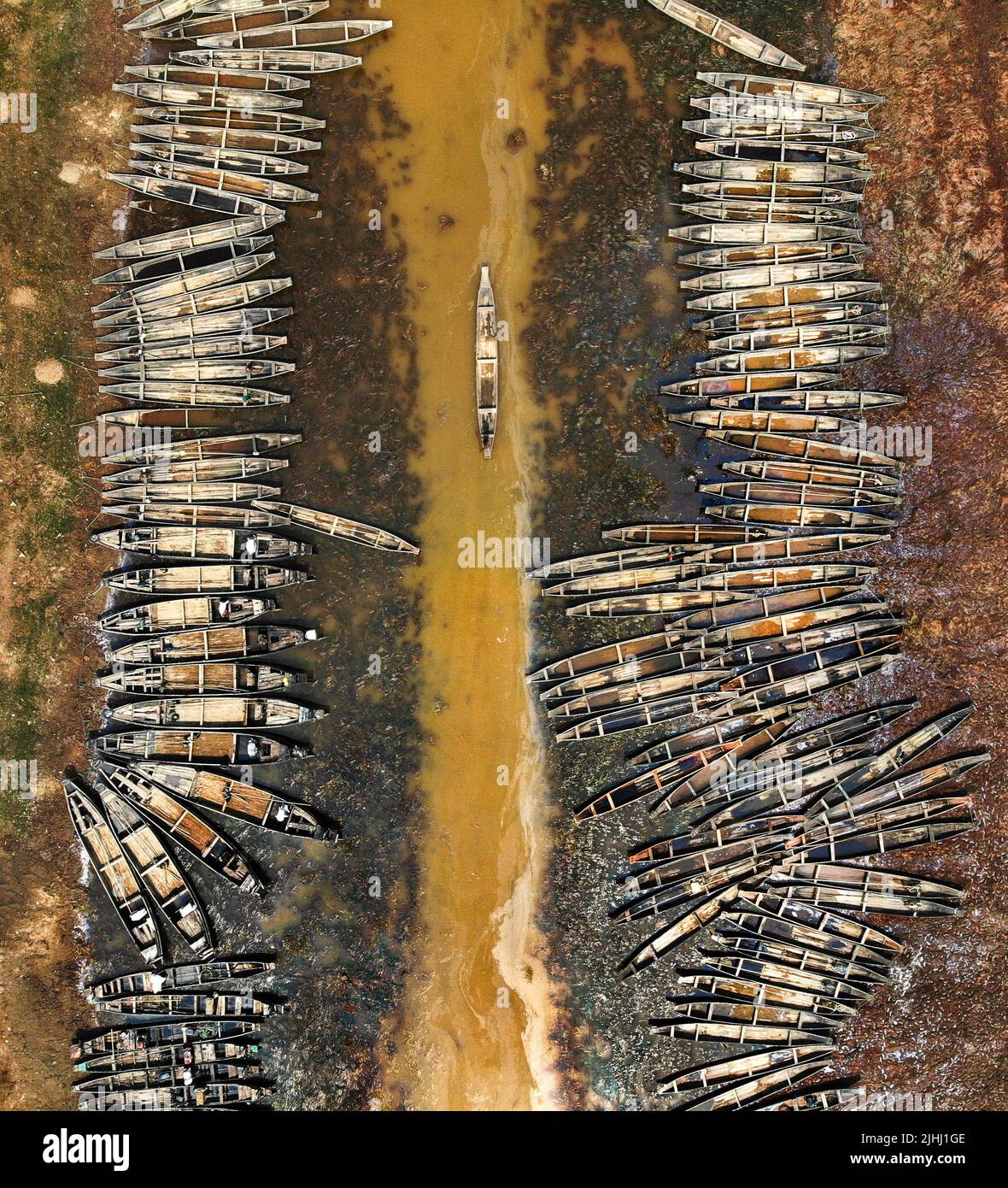 Am Flussufer sind hölzerne Boote aufgestellt, die verschiedene schöne visuelle Muster geschaffen haben. Stockfoto