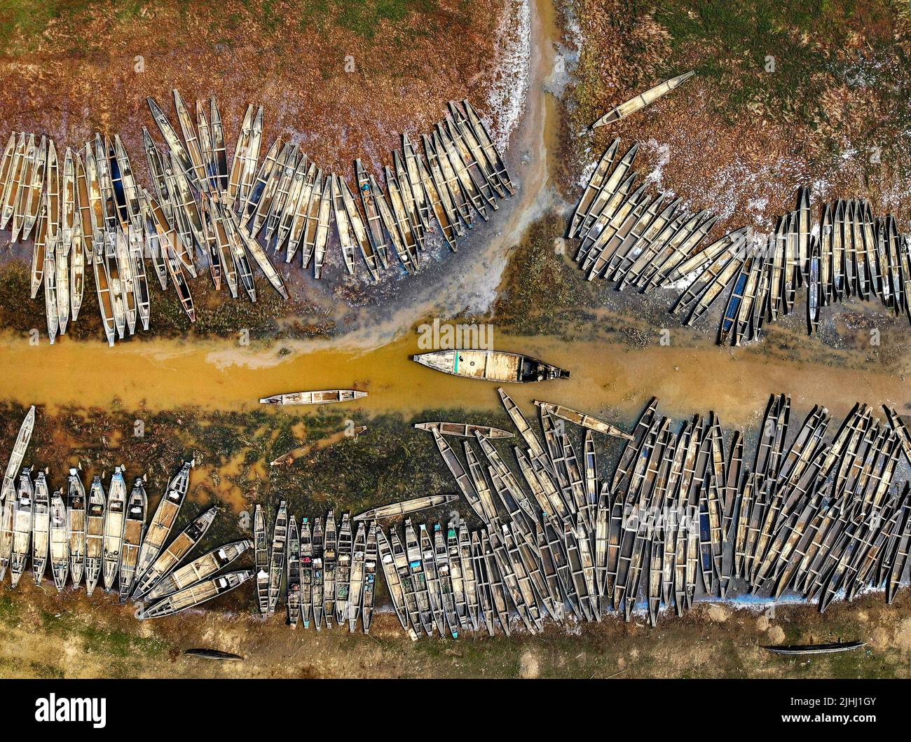 Am Flussufer sind hölzerne Boote aufgestellt, die verschiedene schöne visuelle Muster geschaffen haben. Stockfoto