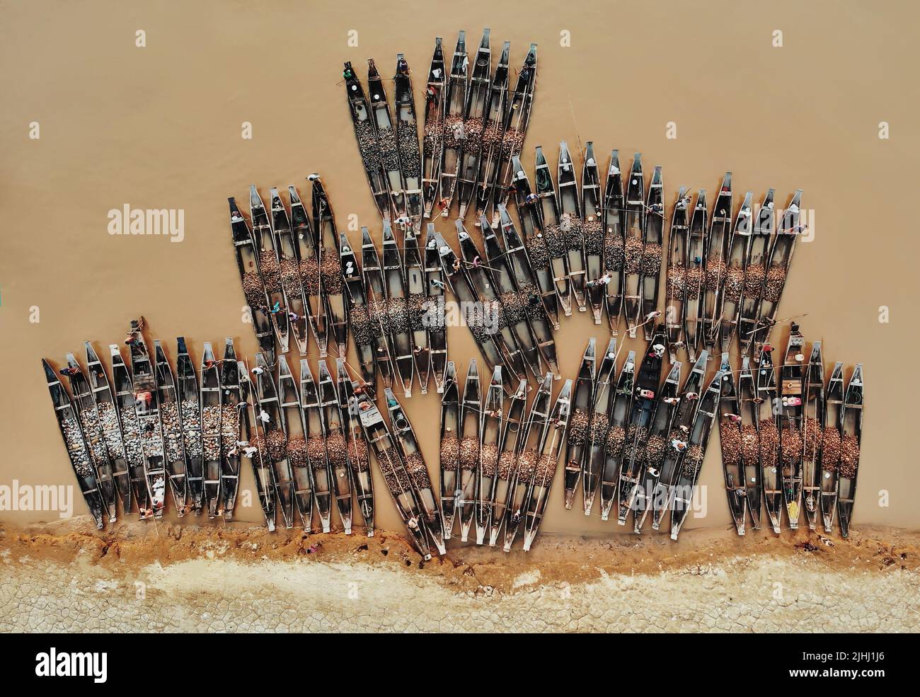 Am Flussufer sind hölzerne Boote aufgestellt, die verschiedene schöne visuelle Muster geschaffen haben. Stockfoto